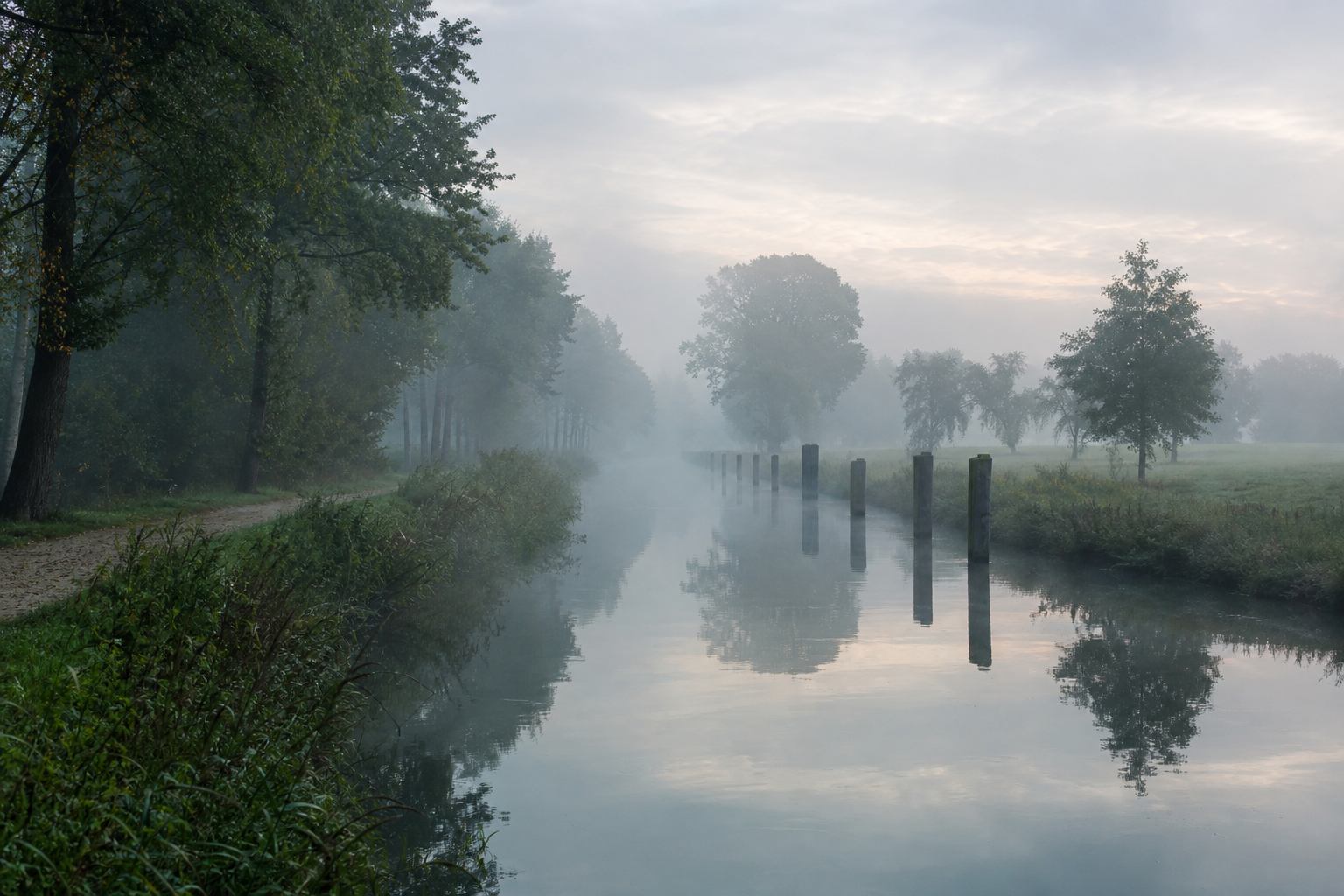 Nebeliger Morgen über einem schmalen norddeutschen Kanal